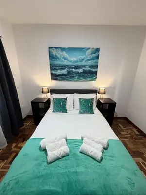 a bedroom with a large bed with two pillows at Ocean View Guest House in São Vicente
