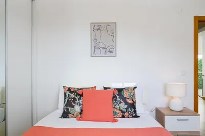 a bedroom with a bed with a red pillow at Garajau Lovers Retreat House 3BR by Wanderlust Madeira in Caniço