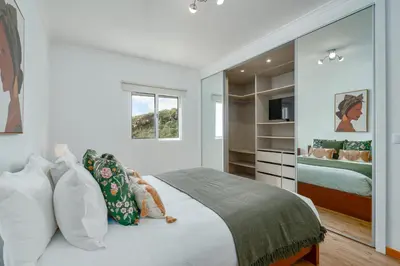 a white bedroom with a bed and a mirror at Garajau Lovers Retreat House 3BR by Wanderlust Madeira in Caniço