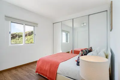 a white bedroom with a bed and a window at Garajau Lovers Retreat House 3BR by Wanderlust Madeira in Caniço
