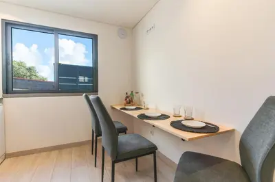 a dining room with a table and chairs and a window at Breeze House 2 by AH in Caniço