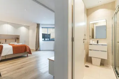 a bedroom with a bed and a bathroom with a shower at Breeze House 2 by AH in Caniço