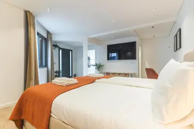 a bedroom with a large white bed with an orange blanket at Breeze House 2 by AH in Caniço
