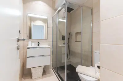 a bathroom with a shower and a toilet and a sink at Breeze House 2 by AH in Caniço