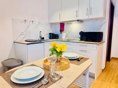 a kitchen with a table with plates and flowers on it at Bela Vista Studio in Ponta Delgada