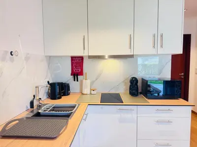 a kitchen with white cabinets and a counter top at Bela Vista Studio in Ponta Delgada