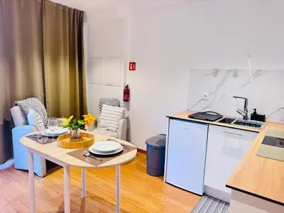 a kitchen with a table and a small kitchen with a sink at Bela Vista Studio in Ponta Delgada