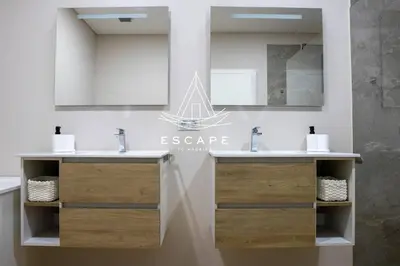 a bathroom with two sinks and a mirror at Villa Golden by Escape to Madeira in Machico
