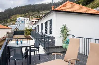 a balcony of a house with a table and chairs at Casa Aguinha by Escape to Madeira in Arco da Calheta