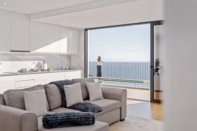 a living room with a couch and a kitchen at Atlantic Bloom by Homie in Santa Maria Maior