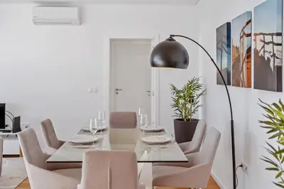 a dining room with a table and chairs and a lamp at Atlantic Bloom by Homie in Santa Maria Maior