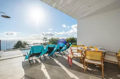 a balcony with a table and chairs and a view at Atlantic Bloom by Homie in Santa Maria Maior