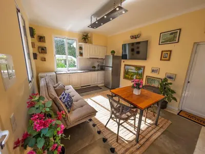 a living room with a table and a kitchen at Casa do Avô Diogo , By OP in Funchal