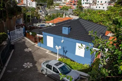 two tables and chairs under an umbrella on a patio at Casa do Avô Diogo , By OP in Funchal