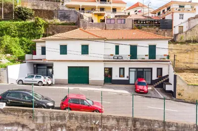 two cars parked in a parking lot in front of a building at Sol Blessing by GALMI in Ponta do Sol