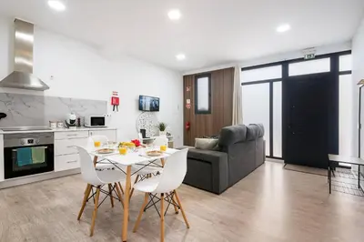 a kitchen and living room with a table and a couch at Sol Blessing by GALMI in Ponta do Sol