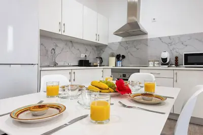a kitchen with a table with plates of food and orange juice at Sol Blessing by GALMI in Ponta do Sol