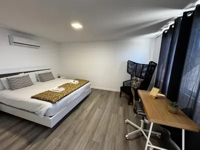 a bedroom with a large white bed and a black curtain at Hiking & Ocean in Arco da Calheta