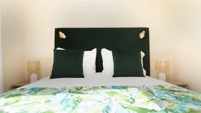a bed with a black headboard and green pillows at Casa da Fazenda by LovelyStay in Gaula