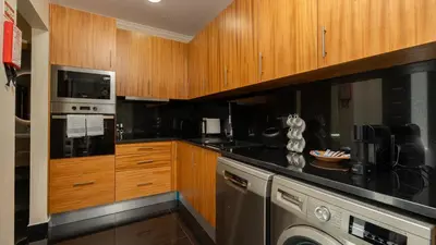 a kitchen with wooden cabinets and a dishwasher at Casa da Fazenda by LovelyStay in Gaula