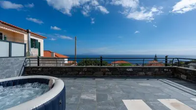 a hot tub on a patio with the ocean in the background at Casa da Fazenda by LovelyStay in Gaula