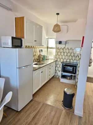 a kitchen with white cabinets and a white refrigerator at Casa Salema Praia Clube in Salema