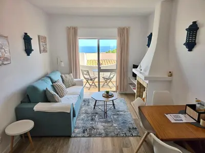 a dining room with a table and chairs and a fireplace at Casa Salema Praia Clube in Salema