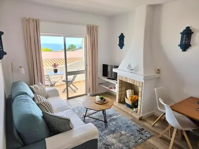 a living room with a couch and a fireplace at Casa Salema Praia Clube in Salema