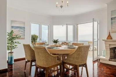 a dining room with a table and chairs and a fireplace at Villa Amor do Mar Ocean View, Panoramas, Jacuzzi in Funchal
