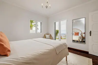 a white bedroom with a bed and a window at Villa Amor do Mar Ocean View, Panoramas, Jacuzzi in Funchal