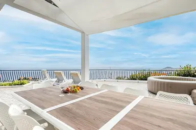 a table and chairs on a patio with a view of the ocean at Villa Amor do Mar Ocean View, Panoramas, Jacuzzi in Funchal