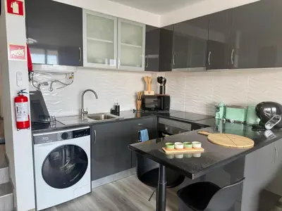 a kitchen with a sink and a washing machine at Seaview Suite in Caniço