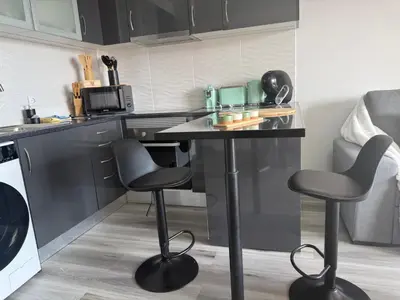a kitchen with a table and two bar stools at Seaview Suite in Caniço