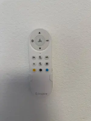 a white remote control hanging on a wall at Seaview Suite in Caniço