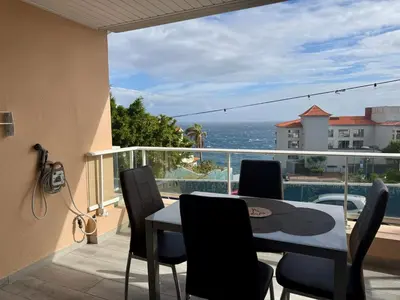 a balcony with a table and chairs and the ocean at Seaview Suite in Caniço