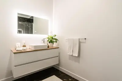 a white bathroom with a sink and a mirror at Casa Joaquim by Rent2u, Lda in Arco da Calheta