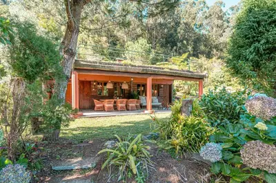 a house with an outdoor living area in a garden at Quintinha de São Jorge in Santana