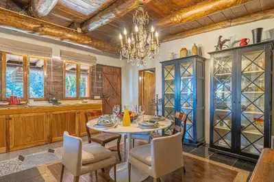 a dining room with a table and chairs and a chandelier at Quintinha de São Jorge in Santana
