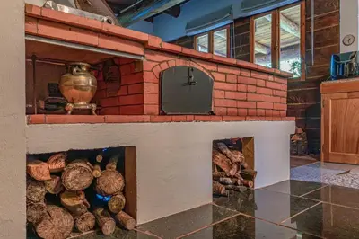a brick oven with a bunch of logs at Quintinha de São Jorge in Santana