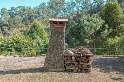 a stack of fire wood in front of a tower at Quintinha de São Jorge in Santana