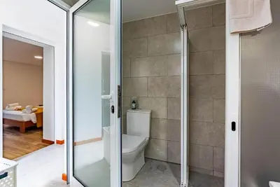 a bathroom with a toilet and a glass shower at Casa do Manuel Maria in Estreito da Calheta