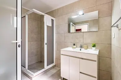 a bathroom with a sink and a shower and a mirror at Casa do Manuel Maria in Estreito da Calheta