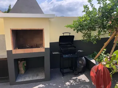 a fireplace in a house with a laptop on a table at Casa do Manuel Maria in Estreito da Calheta