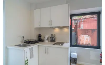 a living room with a table and a tv on the wall at Casa AZUL Apartments in Jardim do Mar