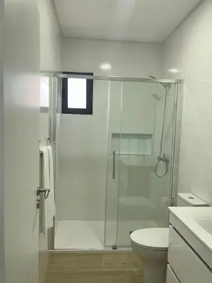 a white bathroom with a shower and a toilet at Cozy Noia in Machico