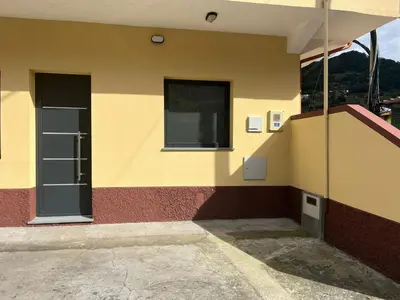 a side of a building with a window and a door at Cozy Noia in Machico