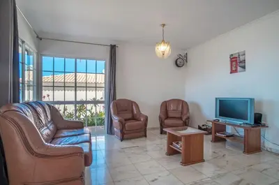 a living room with two chairs and a television at Villa Boa nova in Funchal