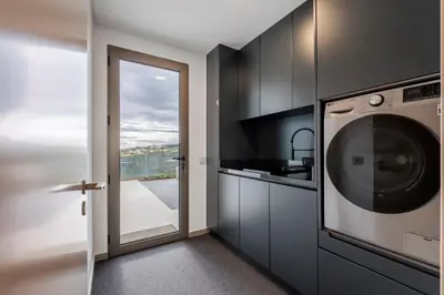 a kitchen with a washer and dryer next to a door at Half Gate Villa in Gaula