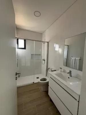 a white bathroom with a toilet and a sink at Cozy Noia in Machico
