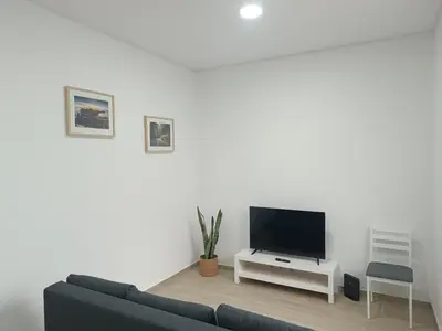 a living room with a couch and a flat screen tv at Cozy Noia in Machico